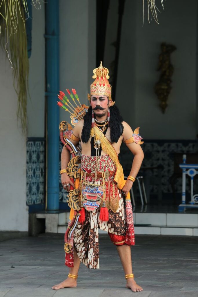 Javanese performer dressed in traditional wayang golek costume in an indoor setting.