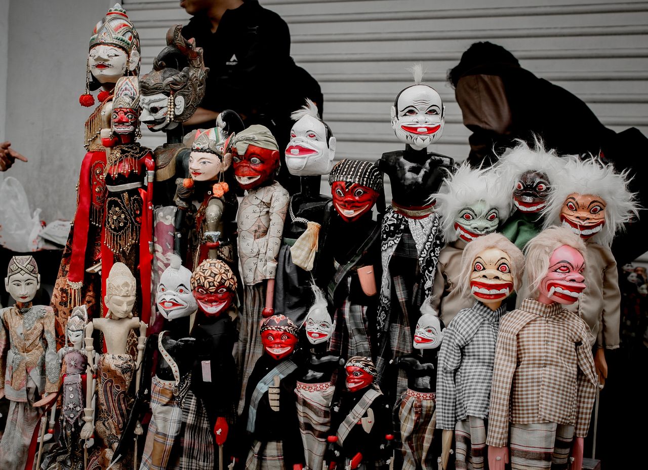 Mastering the First Impression: Your intriguing post title goes here Unique collection of vibrant traditional puppets with expressive faces on display outdoors.